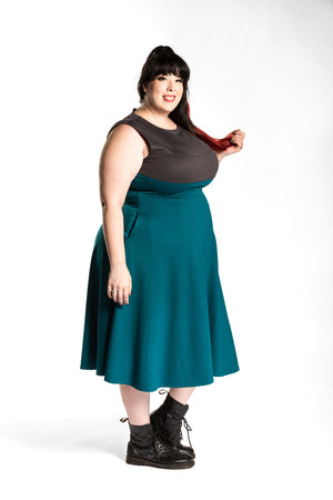 Katie Lynn is wearing the Fighter Longsword Dress - Teal side view. Katie Lynn is wearing a 2X. Her measurements are a 49" Bust, 40" Waist, and 53" Hips, and she is 5'8"