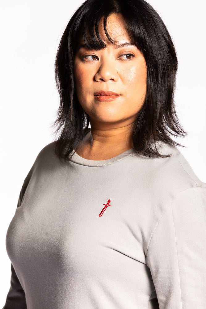 Cheryll wearing the Fighter Shield Pullover - Silver/Ruby close up. Cheryll is wearing a medium. Her measurements are a 40" Bust, 32" Waist, and 40" Hips, and she is 5'4.5"