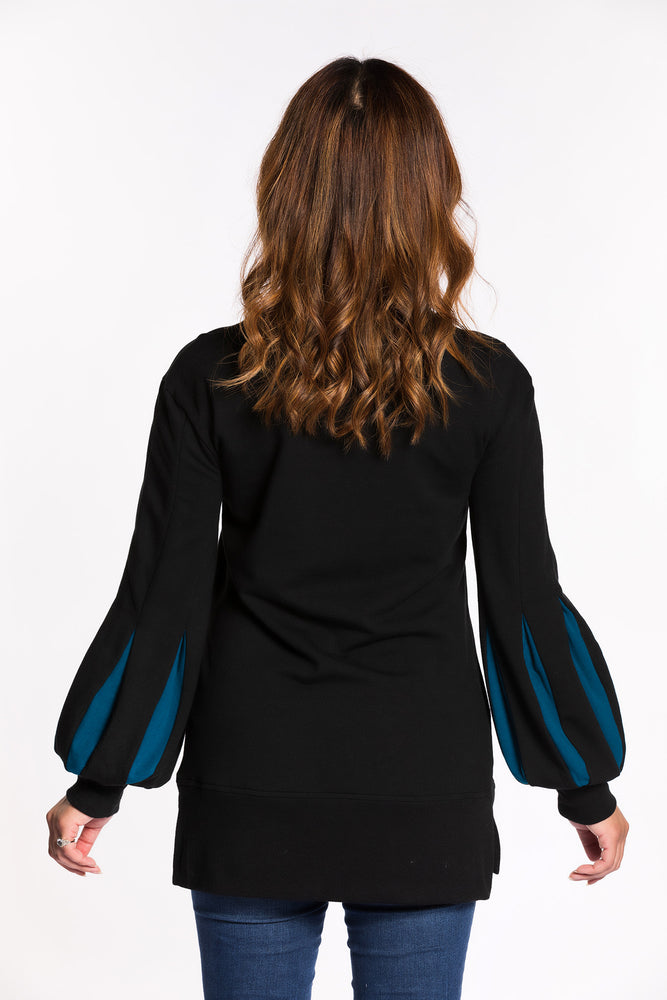 Chelsea wearing the Fighter Shield Pullover - Black/Teal back view. Chelsea is wearing an extra small. Her measurements are 36" Bust, 29" Waist, and 39" Hips, and she is 5'4".