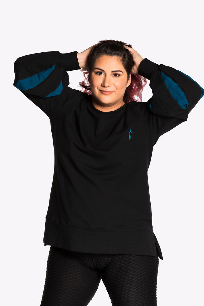 Jessica wearing the Fighter Shield Pullover - Black/Teal. Jessica is wearing an extra large. Her measurements are 47" Bust, 37" Waist, and 46" Hips, and she is 5'6"