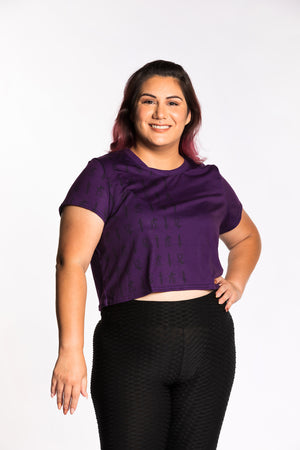 Jessica wearing the Guild Party Logo Crop Tee - Purple/Black. Jessica is wearing an extra large. Her measurements are a 47" Bust, 37" Waist, and 46" Hips, and she is 5'6"