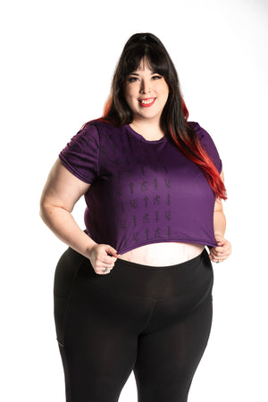 Katie Lynn wearing the Guild Party Logo Crop Tee - Purple/Black. Katie Lynn is wearing a 2X. Her measurements are a 49" Bust, 40" Waist, and 53" Hips, and she is 5'8"