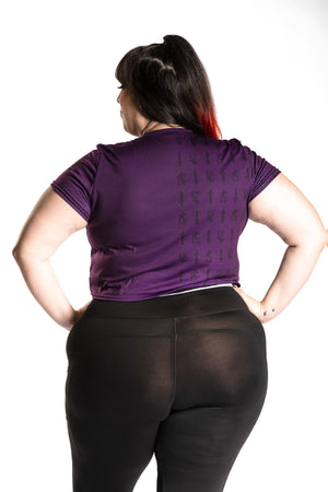 Katie Lynn wearing the Guild Party Logo Crop Tee - Purple/Black back view. Katie Lynn is wearing a 2X. Her measurements are a 49" Bust, 40" Waist, and 53" Hips, and she is 5'8"