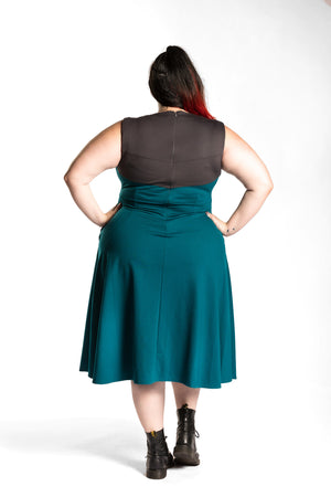 Katie Lynn is wearing the Fighter Longsword Dress - Teal back view. Katie Lynn is wearing a 2X. Her measurements are a 49" Bust, 40" Waist, and 53" Hips, and she is 5'8"
